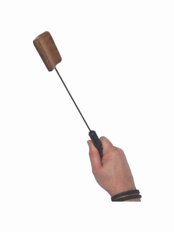 Hand holding a Spoon for testicle and CBT play.